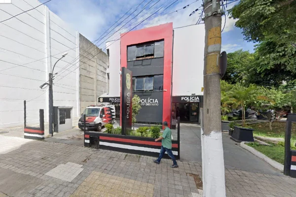 Imagem colorida da fachada do 77º Distrito Policial. Metrópoles