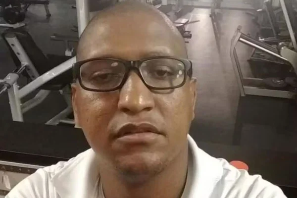 Imagem de homem negro, careca e com óculos, em frente a equipamentos de academia - Metrópoles
