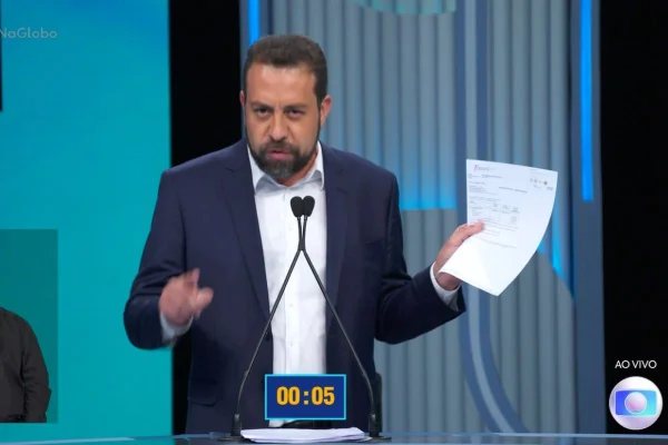 Imagem colorida mostra Guilherme Boulos segurando um papel em debate - Metrópoles