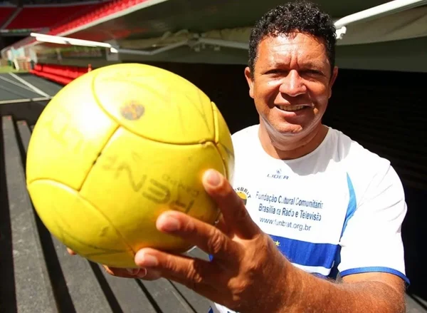 Imagem colorida de homem com camisa branca segurando uma bola de futebol. Briga por herança - Metrópoles