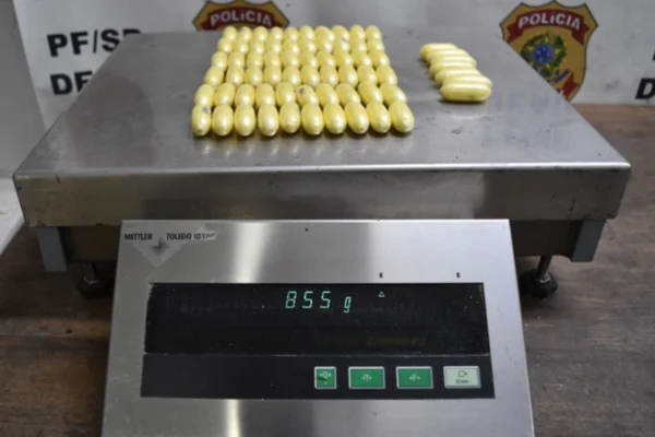 Imagem colorida de cápsulas de cocaína apreendidas com uma mulher pela polícia federal - Metrópoles