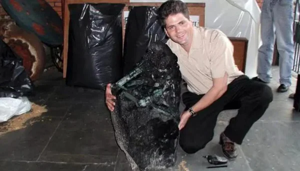 Foto colorida de homem abraçado com a maior esmeralda do mundo - Metrópoles