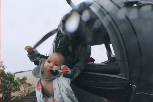 Imagem colorida, bebê Anthony sendo resgatado de helicóptero - Metrópoles