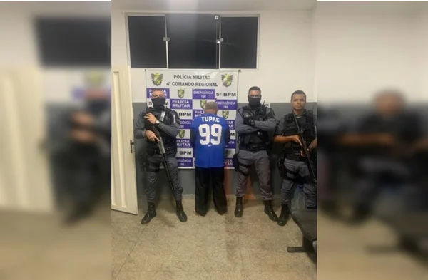 foto de um homem que vesta uma camisa azul sendo preso e três policiasi posando para foto em volta dele