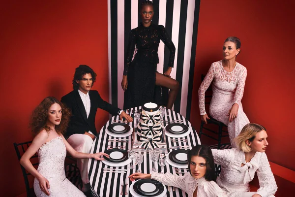 Em campanha de moda, modelos estão ao redor de mesa com utensílios e looks em preto e branco - Metrópoles