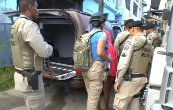Imagem colorida de PM resgatando família - Metrópoles