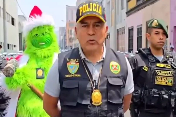 Imagem colorida de policiais ao lado de agente vestido de Grinch - Metrópoles