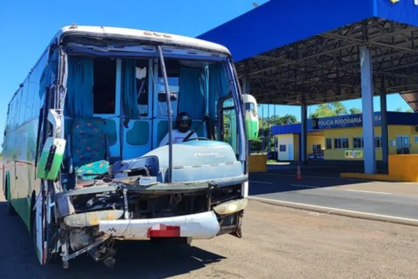 Foto colorida de homem detido dirigindo ônibus sem para-brisas e de capacete