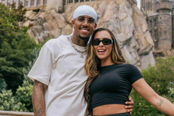 Na imagem colorida, Éder Militão e Tainá Castro posam para a foto. Ambos usam óculos de sol em parque temático - Metrópoles