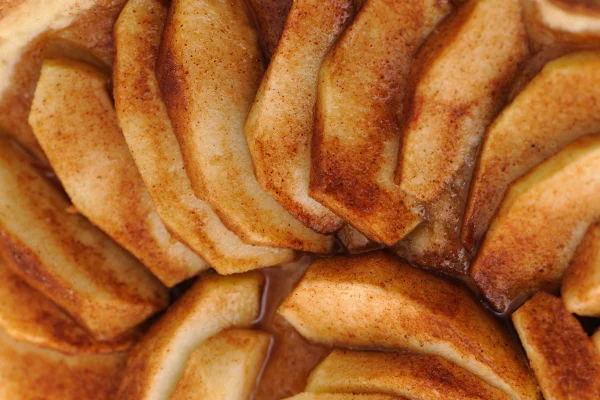 Imagem mostra várias fatias de maçã com canela - Metrópoles