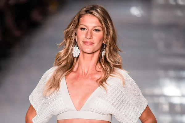 Foto colorida. Mulher branca, loira e modelo durante desfile. A imagem mostra do quadril para cima gisele bundchen - Metrópoles